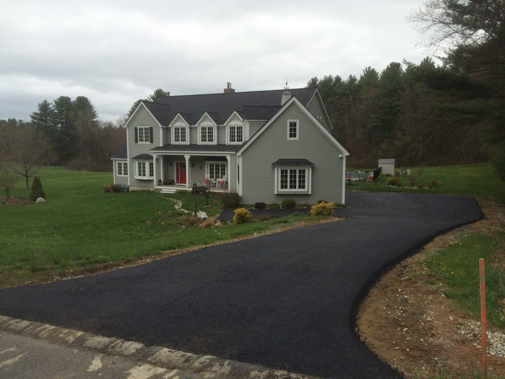 Double story grey house with winding black asphalt driveway laid by Shattuck paving